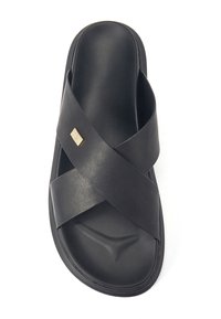 Čierne šľapky s prekríženými pásikmi, vyrobené z hladkej kože, so zateplenou stielkou a detailom v zlatej farbe.