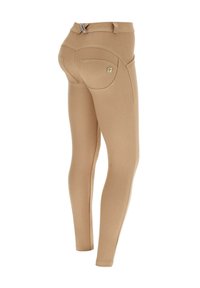 Hiekanväriset, istuvat ratsastushousut, joissa on vyölenkit ja takatasku, kuvattuna takaa valkoisella taustalla.