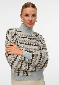 Strick-Turtleneck-Pullover mit geometrischem Muster in Beige, Grau und Schwarz, mit gerippten Bündchen und lässiger Passform. Weicher Stoff, warmes Material.