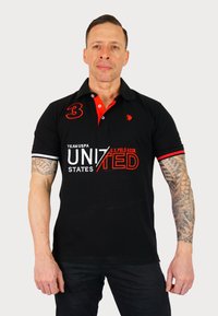 Svart polo t-shirt med röda detaljer, med broderad logotyp och text, korta ärmar med kontrasterande ränder och nummer 3 på bröstet.
