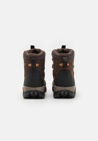 Brązowe buty trekkingowe wykonane z zamszu i materiałów syntetycznych, z wyściółką w kołnierzu, wzmocnionym piętą i gumową podeszwą. Posiadają czarne akcenty i uchwyt.