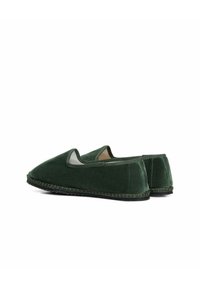 Scarpe slip-on in velluto verde con profilo basso, punta rotonda, aperture laterali elastiche e cucitura in contrasto lungo la suola.