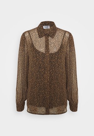 Blouse marron transparente à motif léopard, col boutonné, manches longues et coupe décontractée. Texture douce et tissu léger.