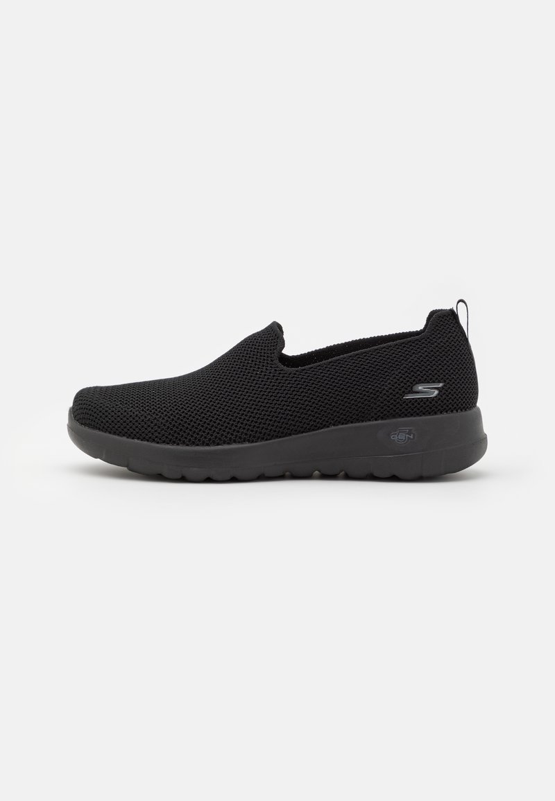 Chaussures noires sans lacets en tissu maille respirant ; bout arrondi ; surface texturée ; semelle en caoutchouc flexible ; logo discret sur le côté.
