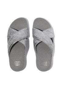 Zilverkleurige slidesandalen met gekruiste bandjes van gestructureerd materiaal, voorzien van een grijze rubberen zool en een logo in reliëf op het voetbed.