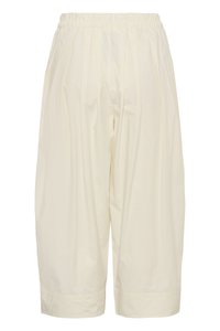 Shorts crème amples, longueur genou, avec taille élastique et plis verticaux subtils.