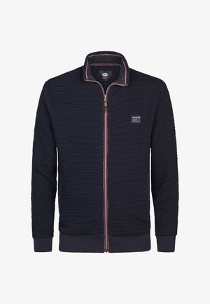 Navy zip-up sweater made of textured fabric, featuring a stand collar, red and white accents, two front pockets, and a logo patch.
