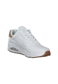 Sneaker bianco con tomaia in pelle liscia, punta rotonda e un accento in suede marrone sul tallone. Presenta dettagli perforati e una soletta con ammortizzazione.