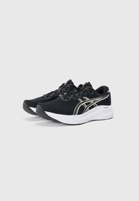 Baskets de sport noires avec une tige texturée, des accents argent métallisé et une semelle blanche rembourrée. Comprend des lacets et un bout arrondi.