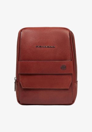 Kompakte braune Ledertasche mit einem Reißverschluss, einer vorderen Klappentasche und Metallmarkenlogos auf der Vorderseite.