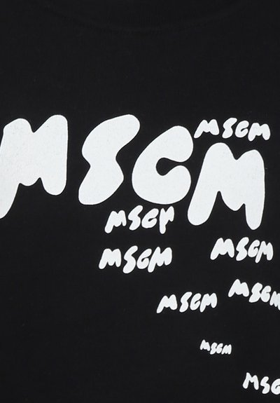 T-shirt nera con grande testo bianco che recita "MSCM" in varie dimensioni e stili, creando un motivo dinamico su tutta la stoffa.
