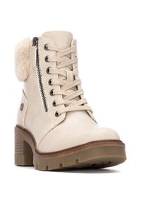 Botín de tobillo de cuero beige con un acento de piel sintética, cremallera lateral, diseño de cordones y un tacón grueso y texturizado con suela antideslizante.