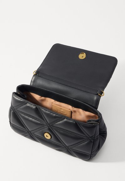 Melna izšūta ādas soma ar zelta pogas aizdari. Iekšpusē ir gaiši brūns oderējums un logo birka. Forma noapaļota ar plakanu augšpusi.