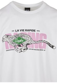 Hvit bomull t-skjorte med et grafisk motiv av en leopard i svart med flekker, grønn "Cayler" logo, og rosa tekst "RACING" og "LA VIE RAPIDE."