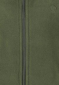 Fleece zip-up jakke i mørkegrøn, med en glat lynlås, blød tekstur og et logo på øverste venstre side.