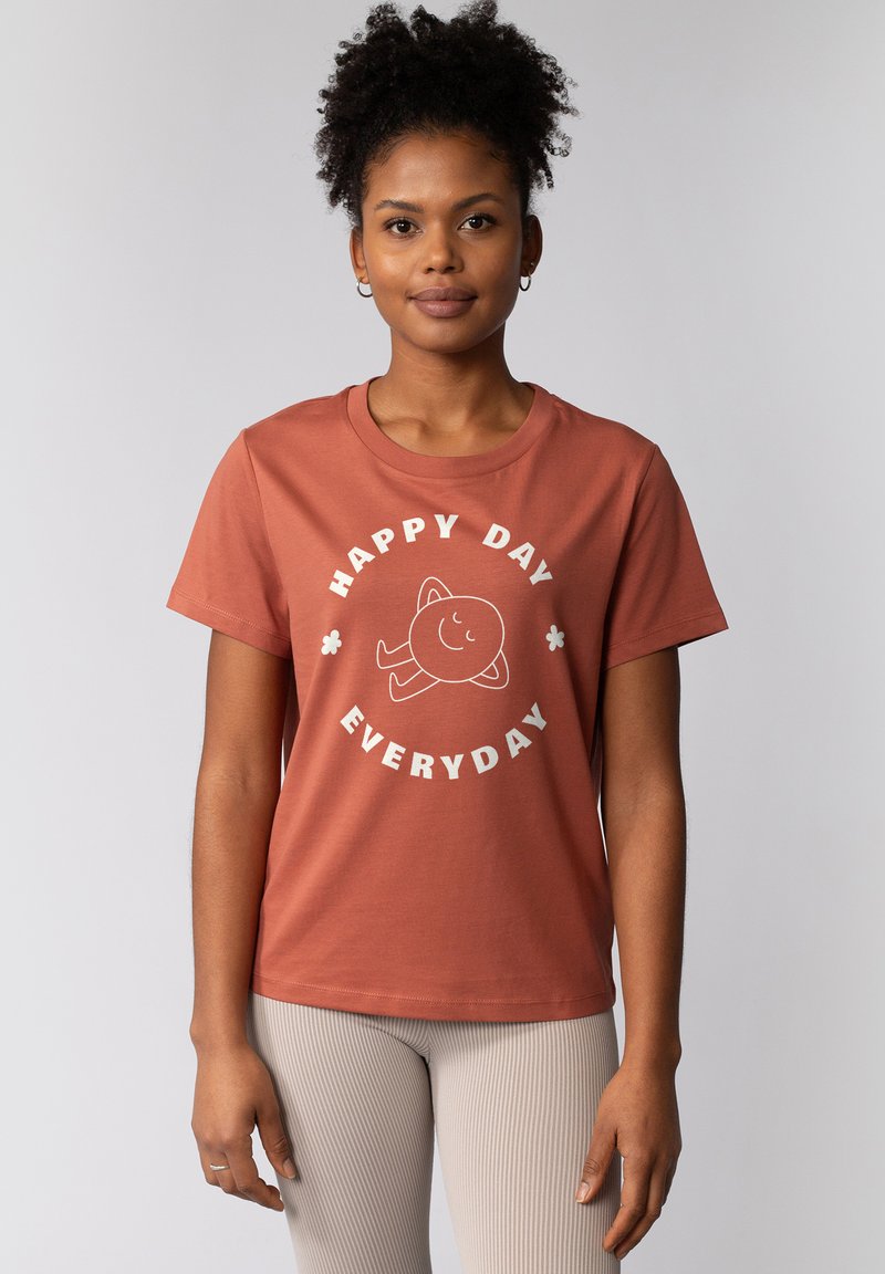 Korte mouwen, roestkleurig katoenen t-shirt met een ronde hals. Voorzien van witte tekst: "HAPPY DAY EVERYDAY" en een glimlachend karakter grafiek.