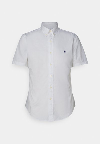 Chemise à manches courtes blanche boutonnée en coton. Dotée d'un col, de boutons jaunes et d'un petit logo bleu sur la poitrine.