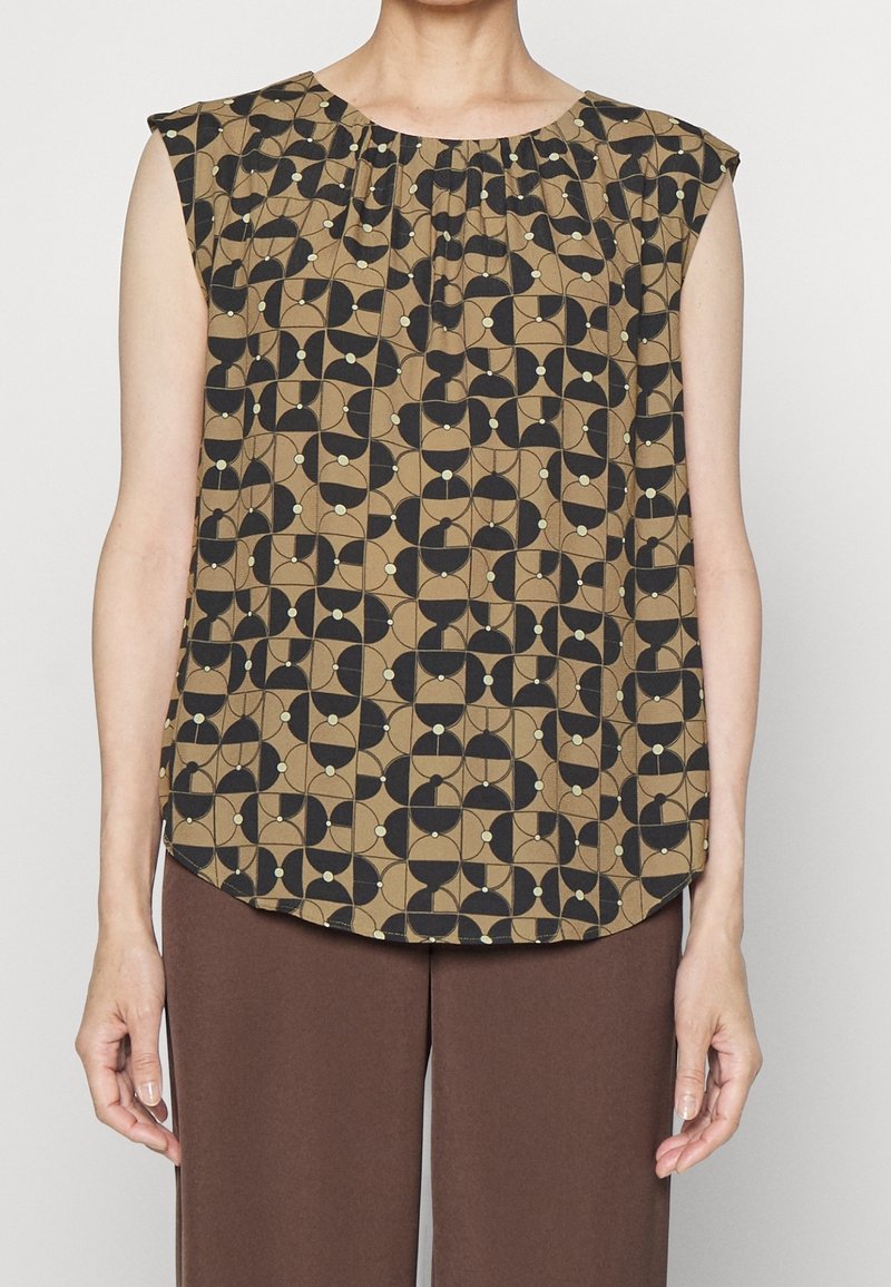 Korte mouw top met een ronde halslijn in bruine stof met een geometrisch zwart en crème patroon. Zachte textuur en licht gebogen zoom.
