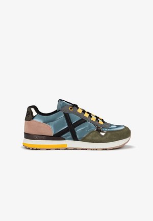 Zapatillas con una combinación de satén azul, ante gris y toques en camel. Presentan rayas negras, cordones amarillos y una suela marrón texturizada.