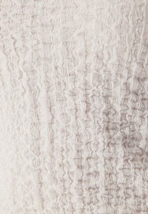 Lätt texturerad tyg med en krusad mönstring i mjuka beige toner. Materialet verkar lätt och flexibelt.