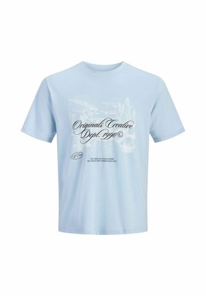 Camiseta de manga corta azul claro con texto en negro "Originals Creative Dept. 1990" y fondo gráfico blanco tenue.