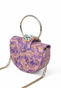 Bolso de mano con patrón morado, cadena dorada y un asa metálica circular. La solapa presenta un arreglo floral de gemas.