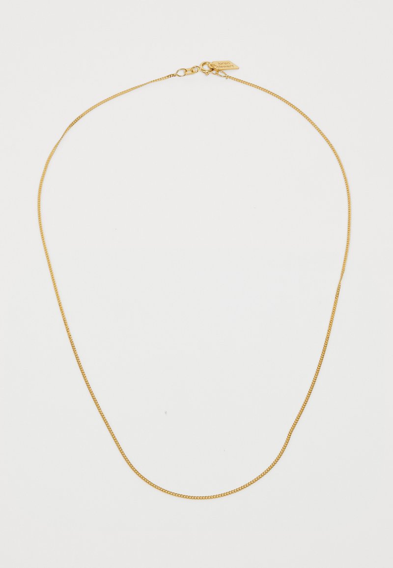 Kuldse tooniga kaelakee, millel on peen ja õhuline kett, koos konksuklambriga ja väikese sildiga aktsendina.