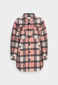 Růžovo-krémová kostkovaná košile z vlněné směsi, která má dvě přední kapsy, černé knoflíky a špičatý límec. Dlouhé rukávy.