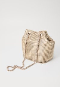 Borsa a secchiello metallizzata dorata con design a rete, dotata di tracolla a catena e occhielli per la chiusura. Texture liscia con una forma strutturata.