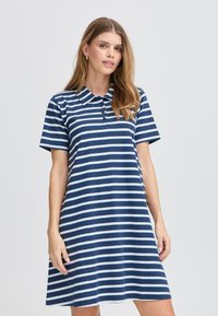 Abito polo a righe in blu navy e azzurro chiaro. Caratterizzato da maniche corte, un colletto e bottoni sul davanti. Realizzato in morbido tessuto leggero.