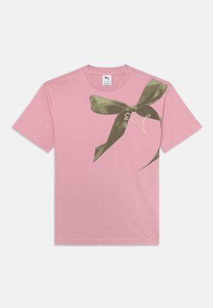 Růžové bavlněné tričko s potiskem khaki zelené mašle a malým bílým logem. Krátké rukávy a kulatý výstřih.