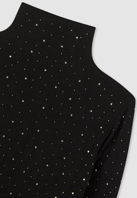 Top a collo polo nero realizzato in tessuto morbido, decorato con pailettes argentate sparse che creano un motivo testurizzato sulla superficie.