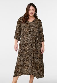 Midiklänning i leopardmönster i ett mjukt tyg, med V-ringning och 3/4 ärmar, en flödande kjol och resår i midjan.