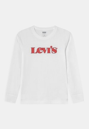 Biała koszulka z długim rękawem i okrągłym dekoltem, z czerwonym logo Levi's na środku klatki piersiowej.