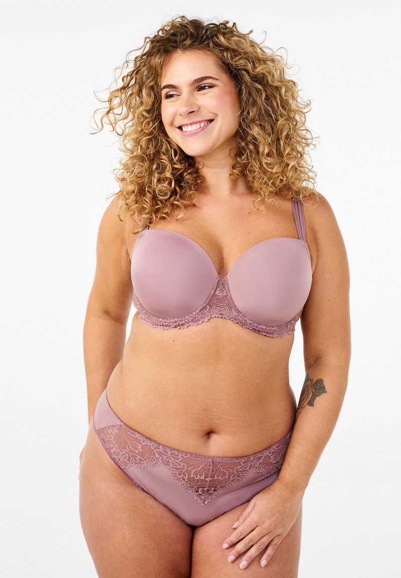 Helles Mauve-BH und passendes Slip-Set. Der BH hat vorgeformte Cups und Spitzenbesätze, die Slips haben Spitzenverzierungen an der Taille. Glatte Textur.