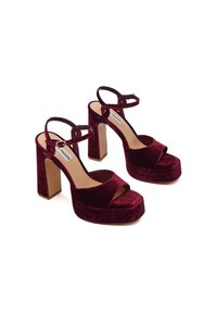 Bordeaux fluwelen hoge hak sandalen met een plateau, open teen, brede band en enkelbandjes. Blokhak ontwerp met een gestructureerde afwerking.