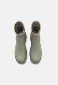 Botas de tobillo verdes de cuero con un diseño elegante, punta redondeada, suela de goma texturizada y una pestaña en la parte trasera para ponérselas fácilmente.