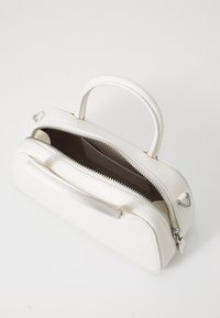 White leather handbag with a double zipper closure, a single top handle, and smooth texture. Interior is lined in brown.