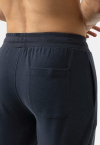 Marineblauwe sportbroeken met een elastische tailleband, voorzien van een enkele achterzak en een soepele katoenstructuur.