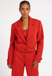 Rode cropped blazer met twee voorzakken, geknipte revers en knoopsluiting. Het heeft een gladde textuur en een getailleerde pasvorm.
