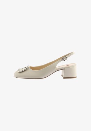 Beżowy skórzany but typu slingback z niskim obcasem typu blok i srebrną klamrą na palcu.