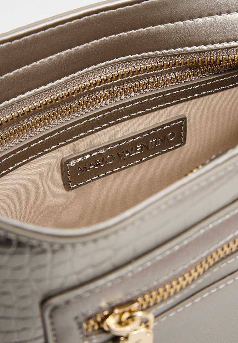 Metallisch graue Handtasche mit Krokodilmuster, goldenen Beschlägen, mehreren Reißverschlussfächern und einem glatten Innenfutter. Logo-Label sichtbar.