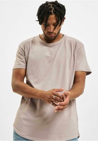 Helebeež toneeritud lühikeste varrukatega crew neck t-särk, mis on valmistatud pehmest puuvillast. Särgil on lõdvestatud lõige ja pisut pikendatud äär.