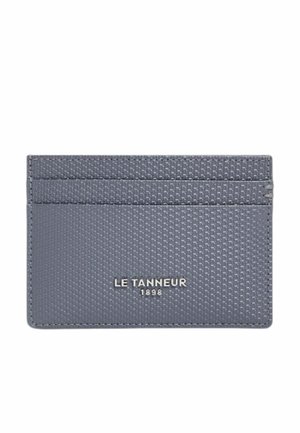 Porta carte grigio texturizzato con tre fessure per carte e logo argentato "LE TANNEUR 1898" centrato sulla parte anteriore.