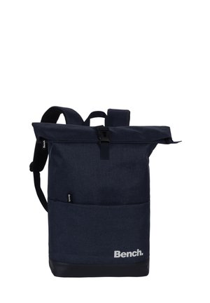 Sac à dos Bench bleu foncé avec fermeture roulée, poche avant, base noire et bretelles réglables sur fond blanc.