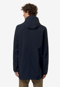 Giacca impermeabile blu navy con cappuccio, caratterizzata da una superficie esterna liscia, un design con parte posteriore più lunga e tasche laterali. Silhouette semplice e moderna.
