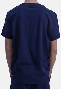 Dunkelblaues Baumwoll-T-Shirt mit kurzen Ärmeln, einem Rundhalsausschnitt und einer schlichten Textur, von hinten präsentiert, mit geradem Schnitt.