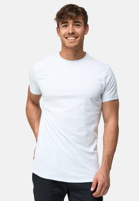 Tricou cu mânecă scurtă de culoare albastru deschis, din bumbac moale, cu guler rotund și un mic logo brodat pe piept. Design ajustat.