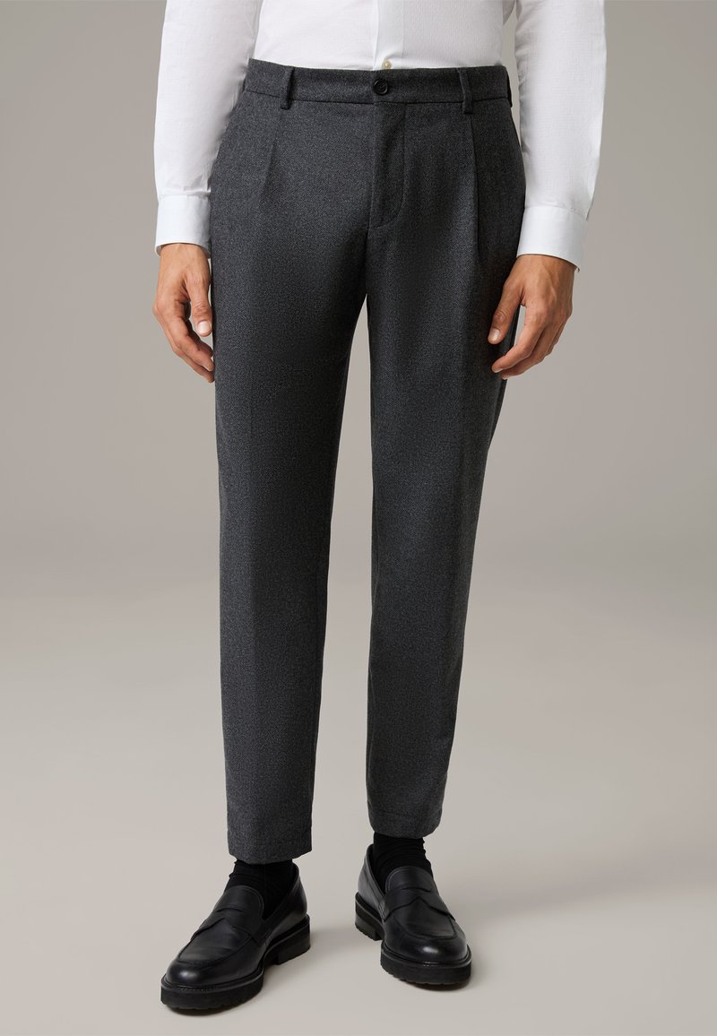Pantaloni grigi su misura, tessuto testurizzato, design plissettato, vestibilità slim, con tasche laterali e un bottone abbinato, abbinati a mocassini neri.