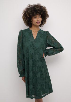 Green lace dress with floral pattern, v-neck, long puffed sleeves, and a relaxed fit. Detailed texture showcases intricate lace design.